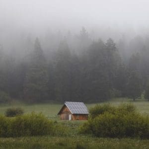 off grid house in the woods with solar power on the roof