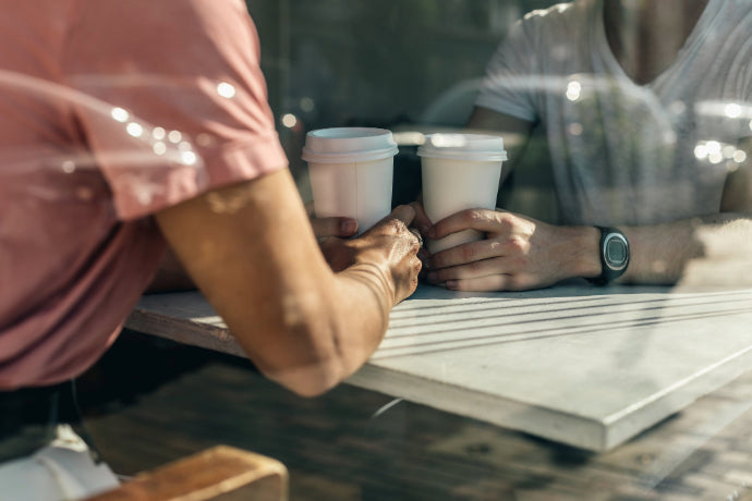Two people chatting at a table in a coffee shop